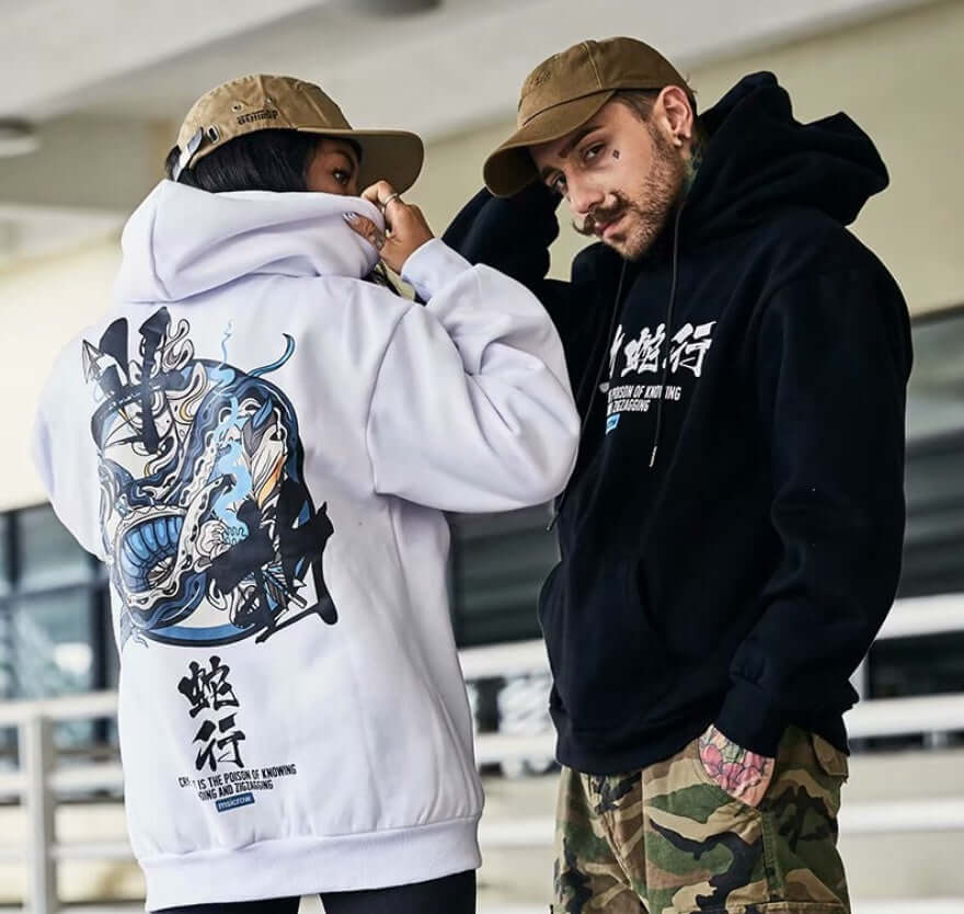 Men's streetwear hoodie with Chinese letters modeled by two people in urban setting.